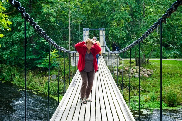 Reife Frau in roter Jacke ruht sich am Fluss aus. — Stockfoto