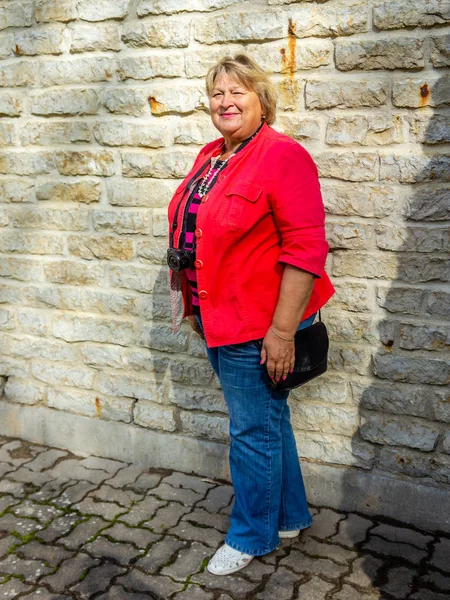 Mujer madura en chaqueta roja descansando en el río . — Foto de Stock