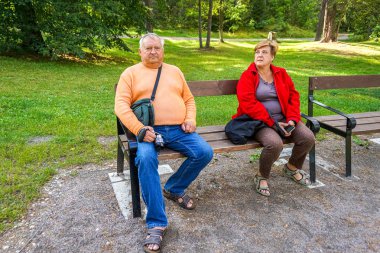 Park bankında otururken dinlenen yaşlı bir çift
