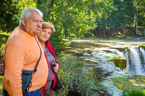 Um casal de idosos descansando em um parque perto de um rio — Fotografia de Stock