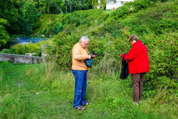 Um casal de idosos descansando em um parque perto de um rio — Fotografia de Stock