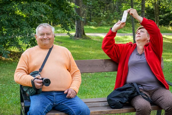 Älteres Ehepaar ruht sich auf Bank im Park aus — Stockfoto