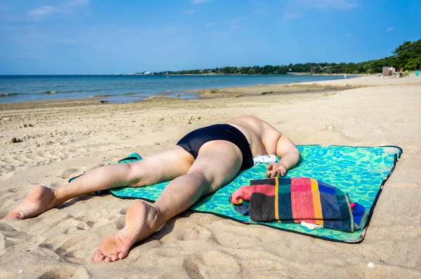 Ώριμη παχουλή γυναίκα που κάνει ηλιοθεραπεία στην παραλία της θάλασσας — Φωτογραφία Αρχείου