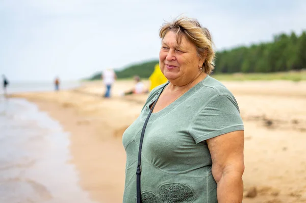 Reife mollige Frau am Strand des Meeres ausruhen. — Stockfoto