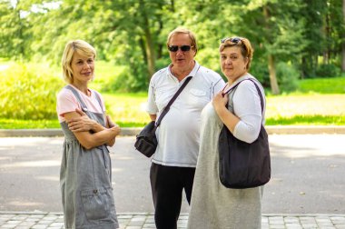 Yaşlı insanlar şehrin sokaklarında yürüyor. 