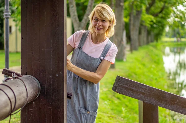 Blonda promenader i stadsparken och leenden brett — Stockfoto