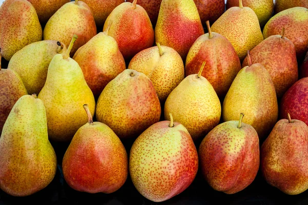 Las peras rojas maduras se encuentran en el mostrador del mercado —  Fotos de Stock