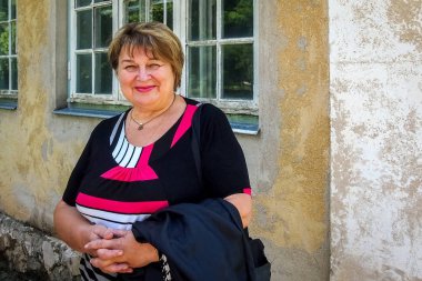 Düşünceli, olgun, tombul kadın sokaklarda yürüyor.