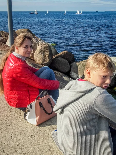 Cara com uma menina na costa do mar Báltico admirando vela — Fotografia de Stock