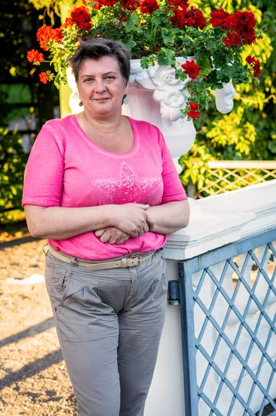 Donna matura in rosso passeggiando per il centro storico . — Foto Stock