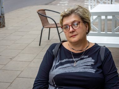 Gözlüklü neşeli, olgun bir kadın fotoğrafçıya gülümsedi. Eski şehrin sokaklarında yürüyorum