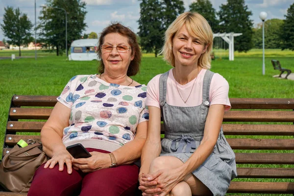 Két Kedves Érett Pihen Egy Városi Parkban Mosolyogva Nézik Fotóst — Stock Fotó
