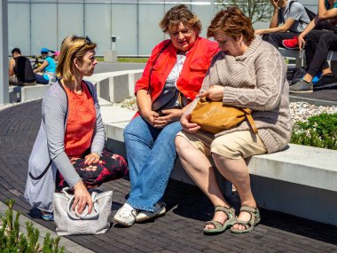 Bir grup olgun turist şehir parkında dinleniyor..