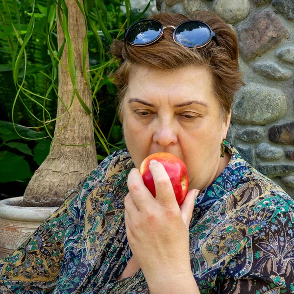 Dojrzała Pulchna Kobieta Przechadza Się Ulicami Starego Miasta Jedzenie Jabłka — Zdjęcie stockowe