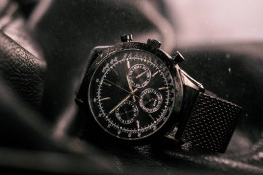 Karanlık bir arka planda siyah bir saat.