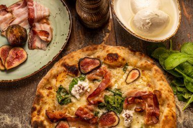 İçinde malzemeler olan bir masada pizza. 