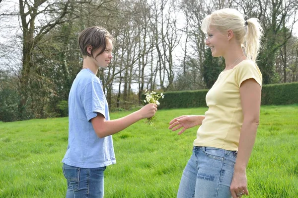 Daughter Offering Flowers Her Mother — Stock Photo, Image
