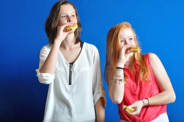 Dos adolescentes comiendo un bollo de chocolate —  Fotos de Stock