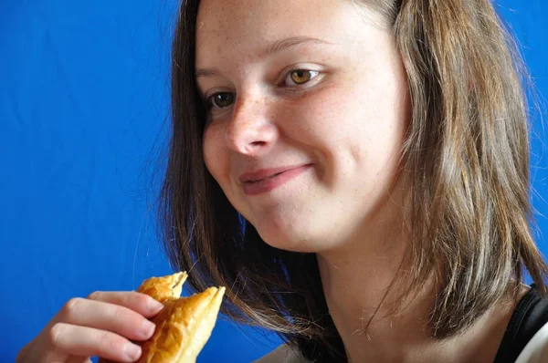 Een tiener die eten van een broodje chocolat — Stockfoto