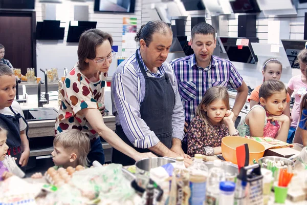 Un chef profesional imparte una clase magistral para niños — Foto de Stock