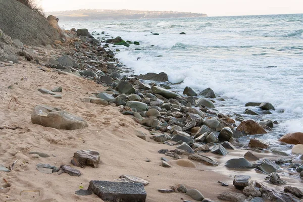 Denizin içinde taş olan Sandy beach Stok Fotoğraf