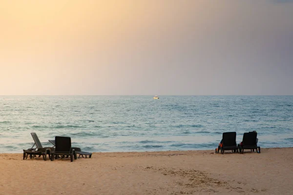 Dos tumbonas de plástico vacías frente al atardecer — Foto de Stock