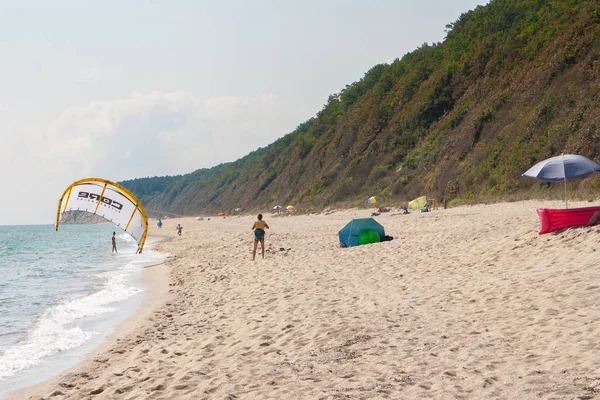 Plano horizontal de una playa de paracaídas y los turistas en la tierra — Foto de Stock