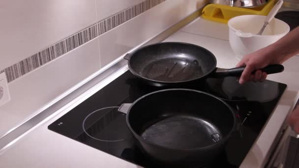 Frying pans with oil on the induction hob. — Stock Video