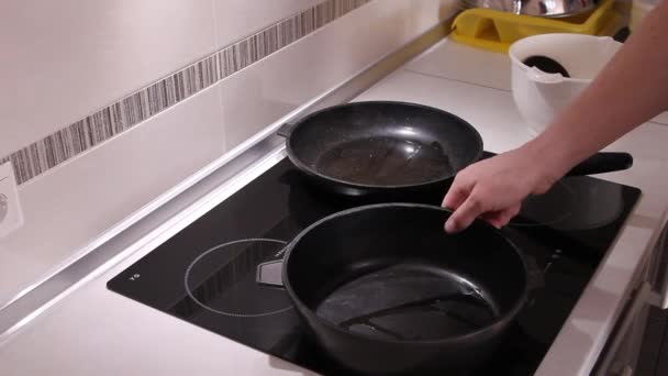 Пальцы проверяют степень нагрева сковороды . — стоковое видео