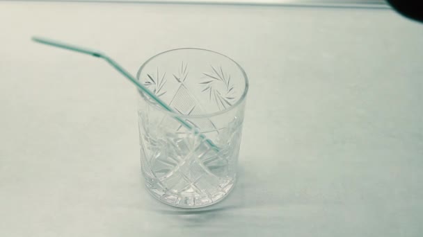 W szklance z rurą koktajlową przelewa różne napoje alkoholowe na przemian — Wideo stockowe