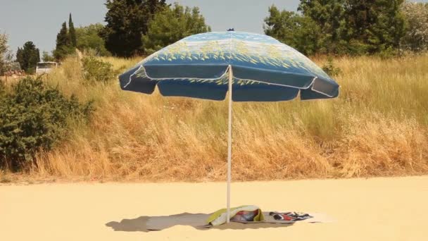 Guarda-chuva de praia com toalhas em uma praia livre — Vídeo de Stock