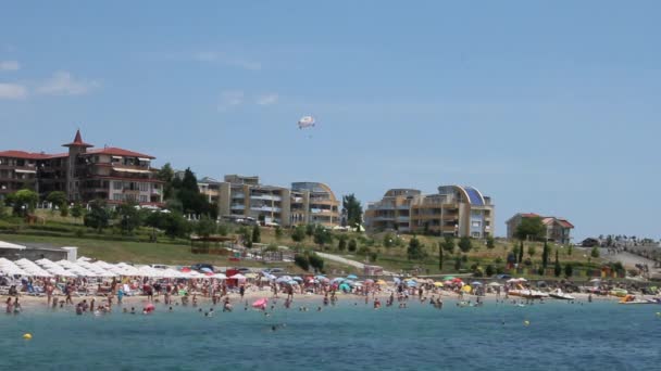 Paracaídas sobre la playa con los turistas en el mar . — Vídeos de Stock