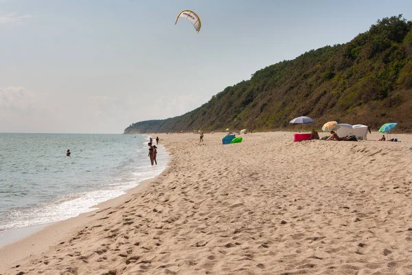 Tiro vertical de una playa de paracaídas y turistas — Foto de Stock