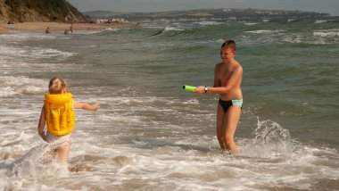 İki çocuk, bir kız ve bir oğlan, bir erkek ve bir kız kardeş, deniz kıyısında oynuyorlar..