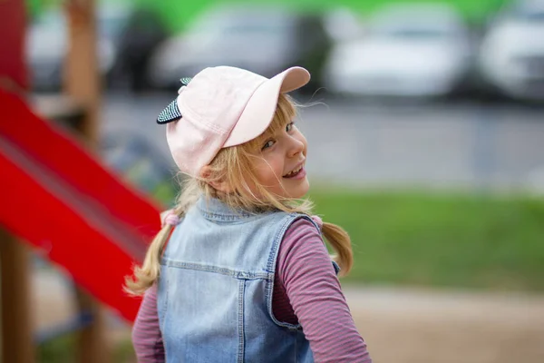 A smiling teenage girl with a slightly disheveled hairdo looks back. — Stock Photo, Image