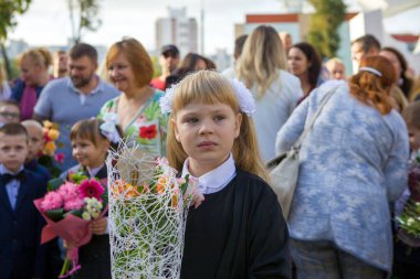 Okuldaki eğitimin ilk gününde birinci sınıftaki küçük kız. Beyaz Rusya.