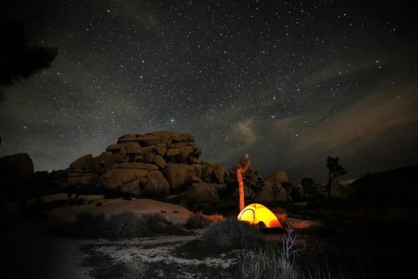 Světlý člověk na poušti pod noční oblohou — Stock fotografie