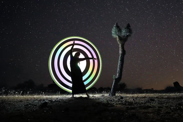 Persoon licht geschilderd in de woestijn onder de nachtelijke hemel — Stockfoto