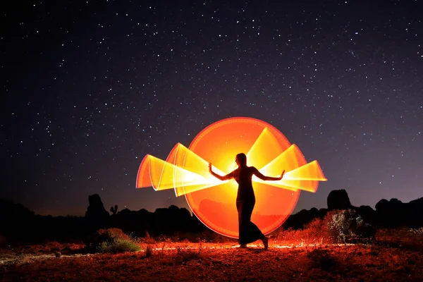 Persona luce dipinta nel deserto sotto il cielo notturno — Foto Stock