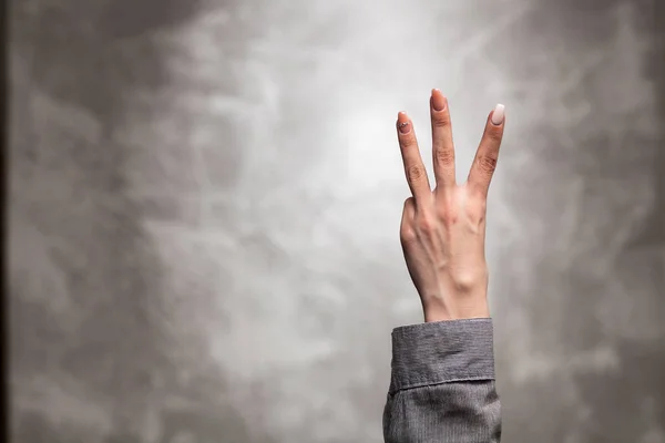 Vrouwelijke hand op donkere achtergrond — Stockfoto