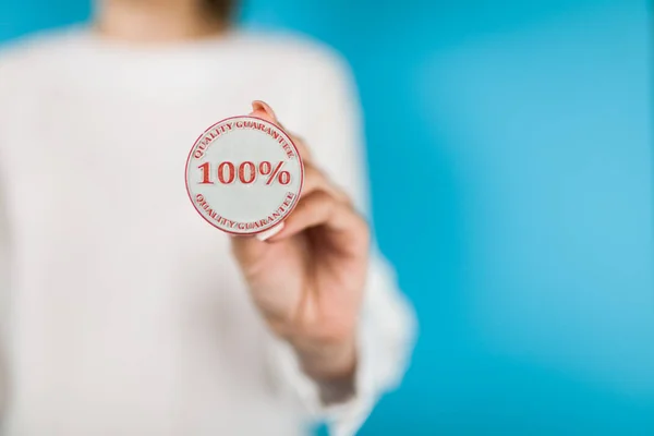 Woman holding hundred percent stamp