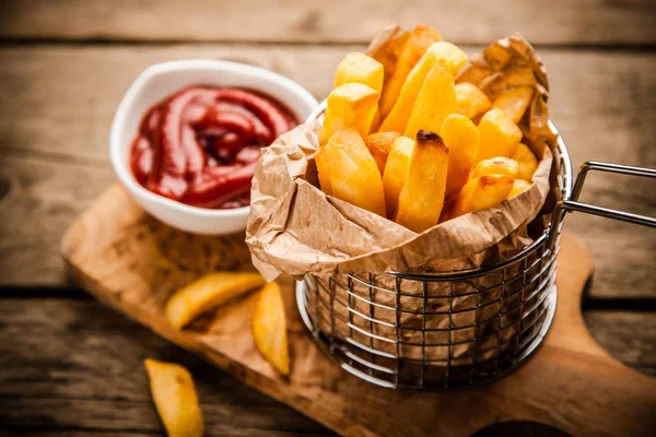 Pommes frites på träbord — Stockfoto