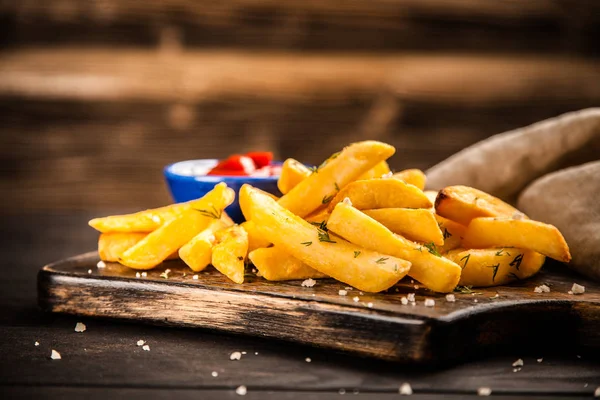 Pommes frites på träbord — Stockfoto