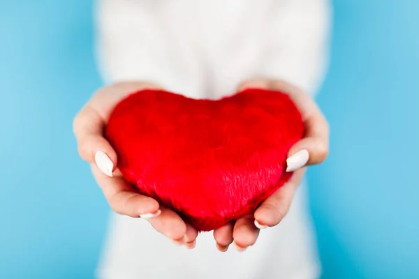 Руки женщины держат красное сердце — стоковое фото