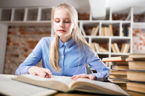 Tiener meisje in een bibliotheek — Stockfoto