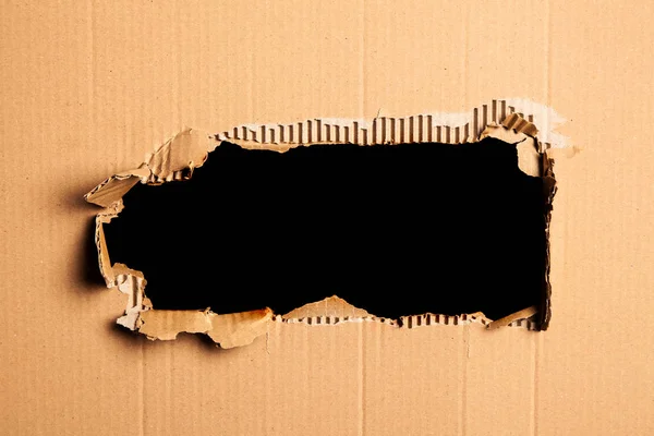 Cardboard with a hole - black background — Stock Photo, Image