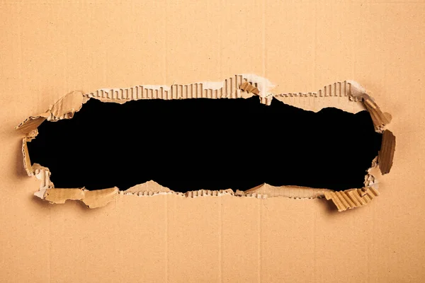 Karton bir delik - siyah arka plan ile — Stok fotoğraf