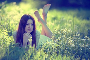 bir çayır üzerinde yatan kız