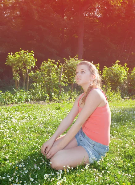 Flicka sitter på gräs — Stockfoto