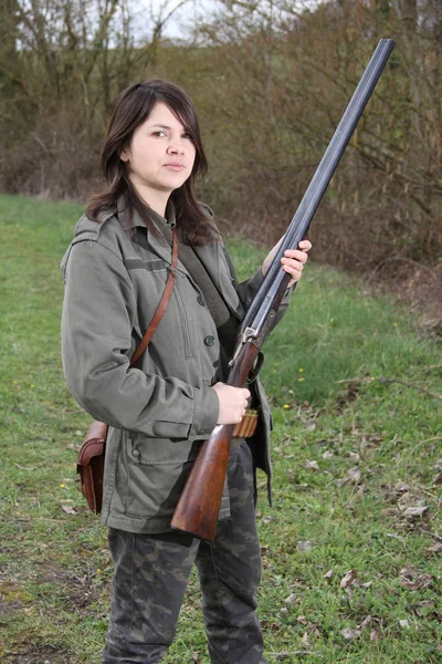 cheerful young woman hunter holding her gun close-up
